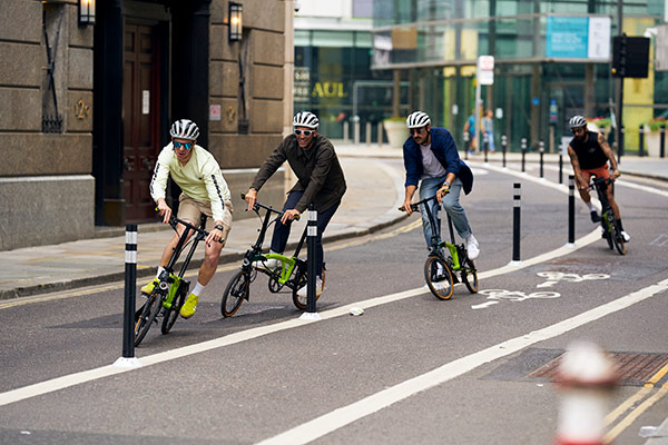 Image of 4 5th floor members riding Bromptons through London