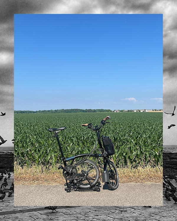 Brompton Electric bike part folded in front of a field on a trip to  Illinois