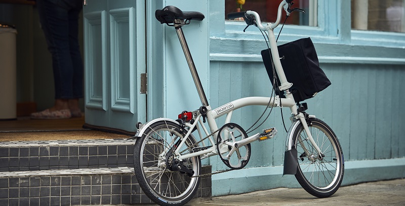 Brompton bike leaning on a wall with rear reflector