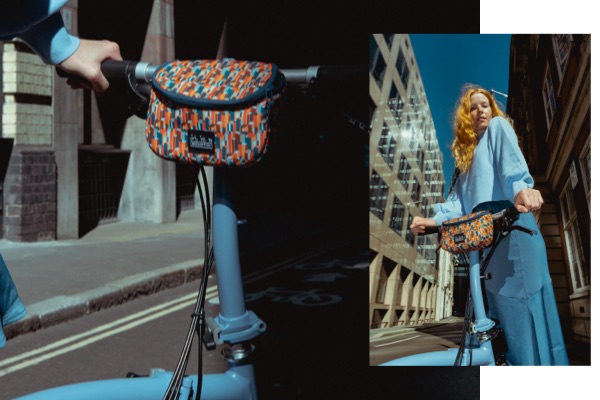 2 images of the Liberty x Brompton Zip Pouch on a Brompton bike in London