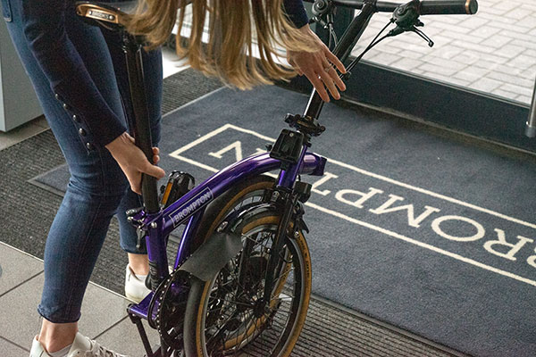 Louise Holbrook unfolding a purple Brompton bike